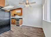 Thumbnail 33 of 52 - A kitchen with a black refrigerator and wooden cabinets.