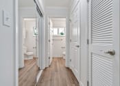 Thumbnail 43 of 52 - A white hallway with wood floors and white doors.