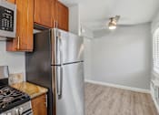 Thumbnail 9 of 17 - A kitchen with a stove, refrigerator, and cabinets.