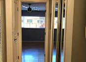 Thumbnail 39 of 47 - A hallway with a ceiling fan and sliding glass doors.