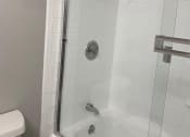 Thumbnail 8 of 10 - a white bathroom with a shower and a toilet