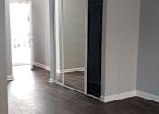Thumbnail 25 of 30 - A room with a sliding door and wood flooring.