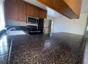 Thumbnail 8 of 26 - a kitchen with a granite counter top and a refrigerator