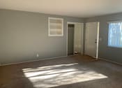 Thumbnail 17 of 37 - A room with a carpeted floor and a window letting in sunlight.