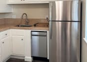 Thumbnail 28 of 36 - a kitchen with a stainless steel refrigerator and a sink