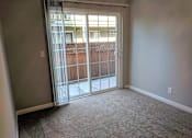 Thumbnail 12 of 63 - A room with a sliding glass door leading to a balcony.