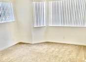 Thumbnail 16 of 26 - A room with a tan carpet and two windows with blinds.