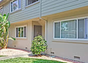 Thumbnail 9 of 34 - A house with a green lawn and a tree in front.