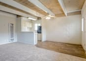 Thumbnail 18 of 32 - A spacious room with wooden floors and a ceiling fan.