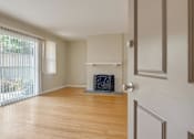 Thumbnail 15 of 37 - A room with a fireplace and a sliding glass door.