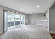 Thumbnail 13 of 53 - an empty living room with sliding glass doors to a balcony