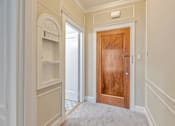 Thumbnail 37 of 42 - A room with a wooden door and a white wall.