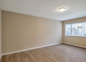 Thumbnail 4 of 13 - an empty living room with wood flooring and a window