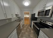 Thumbnail 44 of 47 - A kitchen with black appliances and white cabinets.