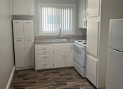 Thumbnail 7 of 14 - a kitchen with white appliances and a wood floor