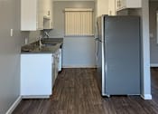 Thumbnail 23 of 37 - A kitchen with a refrigerator, sink, and cabinets.