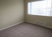 Thumbnail 17 of 31 - an empty living room with a large window and carpet