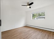 Thumbnail 23 of 33 - A room with a ceiling fan and a window.