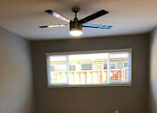 Thumbnail 29 of 47 - A room with a ceiling fan and a window.