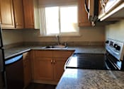 Thumbnail 9 of 22 - A kitchen with wooden cabinets and granite countertops.