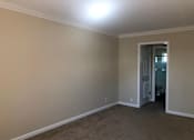 Thumbnail 54 of 62 - a empty living room with a door to a bathroom
