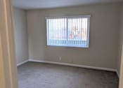 Thumbnail 19 of 42 - A room with a window and carpeted floor.