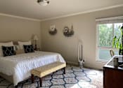 Thumbnail 6 of 22 - A bedroom with a white bed and a yellow bench.