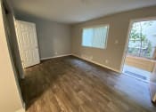 Thumbnail 46 of 51 - an empty living room with wooden floors and a window