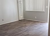 Thumbnail 9 of 37 - A room with wooden flooring and a window with blinds.