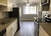 Thumbnail 16 of 43 - A kitchen with black appliances and white cabinets.