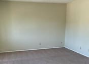 Thumbnail 24 of 33 - A room with a carpeted floor and a white wall.