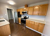 Thumbnail 17 of 41 - a kitchen with wooden cabinets and stainless steel appliances