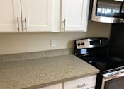 Thumbnail 20 of 62 - a kitchen with white cabinets and a black stove
