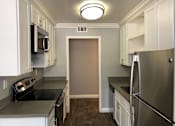 Thumbnail 17 of 43 - A kitchen with white cabinets and a stainless steel refrigerator.