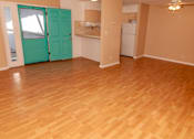 Thumbnail 18 of 25 - an empty living room with a wood floor and a green door