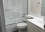Thumbnail 23 of 26 - A white toilet in a bathroom with a glass shower door.
