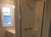 Thumbnail 24 of 31 - A bathroom with a walk in shower and a window.