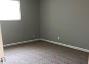 Thumbnail 23 of 33 - A room with a carpeted floor and a window.