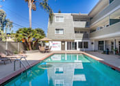 Thumbnail 4 of 23 - the pool is in front of a condo building with a swimming pool