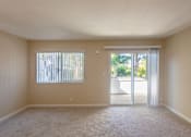 Thumbnail 17 of 23 - an empty living room with sliding glass doors to a patio
