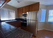 Thumbnail 7 of 26 - an empty kitchen with a stainless steel refrigerator