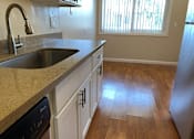 Thumbnail 32 of 62 - a kitchen with a sink and wooden floors