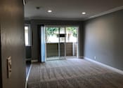 Thumbnail 30 of 43 - A room with a carpeted floor and a sliding glass door leading outside.