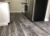 Thumbnail 35 of 62 - a kitchen with wood floors and a refrigerator
