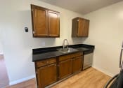Thumbnail 50 of 51 - a kitchen with a sink and wooden cabinets