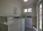 Thumbnail 15 of 51 - a laundry room with four washing machines in it