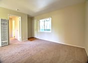 Thumbnail 16 of 20 - A room with a carpeted floor and a window with a white frame.