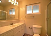 Thumbnail 19 of 20 - A bathroom with a toilet, sink, and mirror.