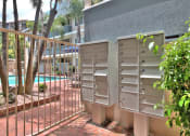 Thumbnail 12 of 31 - a group of mailboxes sitting next to a fence and a swimming pool
