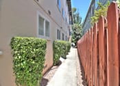 Thumbnail 13 of 31 - a sidewalk in front of an apartment building with a wooden fence